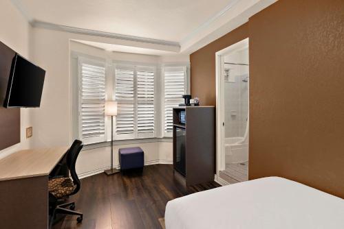 a bedroom with a bed and a desk and a window at Mithila San Francisco - SureStay Collection by Best Western in San Francisco