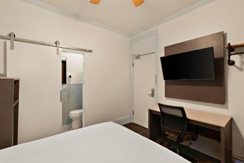 a room with a desk and a tv on the wall at Mithila San Francisco - SureStay Collection by Best Western in San Francisco