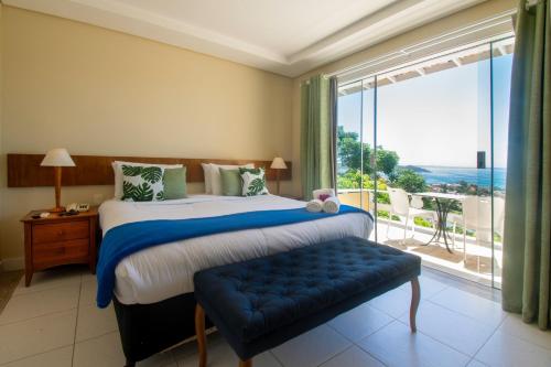 a bedroom with a large bed and a large window at Pousada e Spa Villa Mercedes by Latitud Hoteles in Búzios