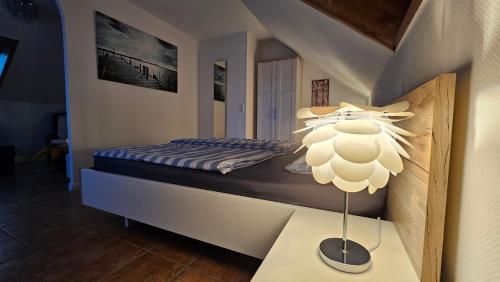 ein Schlafzimmer mit einem Bett und einer Lampe auf einem Tisch in der Unterkunft Surforama Studio Appartement mit Meerblick und Garten in Fehmarn