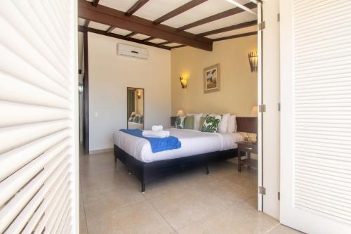 a bedroom with a king sized bed and a table at Pousada e Spa Villa Mercedes by Latitud Hoteles in Búzios