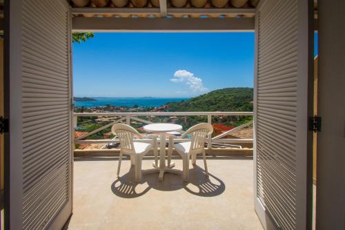 a balcony with a table and chairs and a view at Pousada e Spa Villa Mercedes by Latitud Hoteles in Búzios
