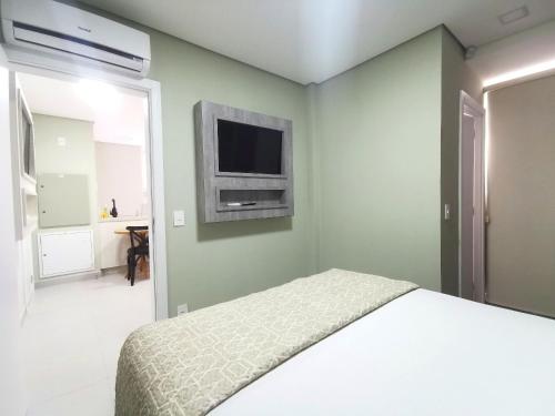 伊瓜蘇的住宿－Click Apê Prime Foz，卧室配有一张床,墙上配有电视。