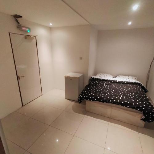 um quarto com uma cama com um edredão preto e branco em VINOX PROPERTY em Chatham