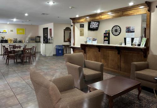 a waiting room with chairs and tables and a counter at Days Inn & Suites by Wyndham Eunice in Eunice