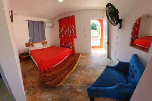 a bedroom with a bed and a blue couch at Villa KIKI Ensenada in Punta Rucia