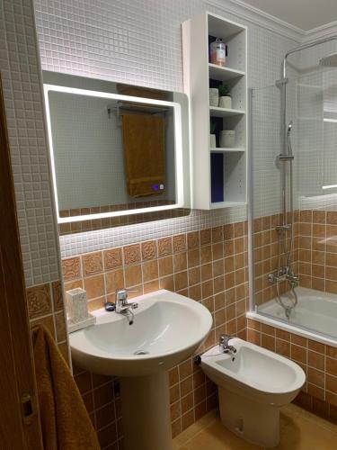 Un baño con lavabo, espejo y bañera. en MANSIÓN DEL INDIANO, en Viveiro