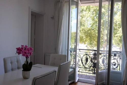 a dining room with a table with a vase of flowers at Eiffel Tower Oasis 30m from Eiffel Tower in Paris