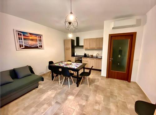 a living room with a dining room table and a kitchen at Agriturismo Stella Marina in Piombino