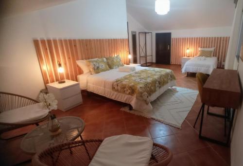 a bedroom with a bed and a table and chairs at O Miradouro in Angra do Heroísmo