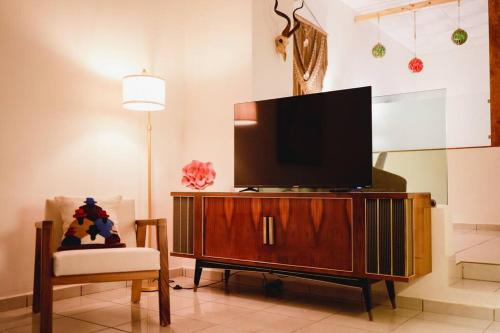 a living room with a flat screen tv on a wooden entertainment center at Casa Amma - Bhakti in Matehuala