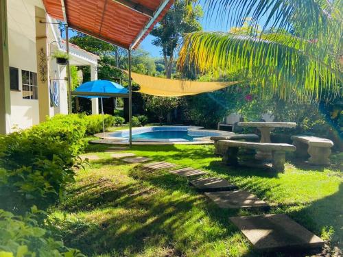 拉列伯塔的住宿－Casa de playa “mi lancho”，一个带吊床和游泳池的后院
