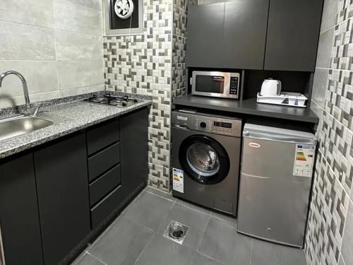 una cucina con lavatrice e forno a microonde di Great apartment with great location ad Amman