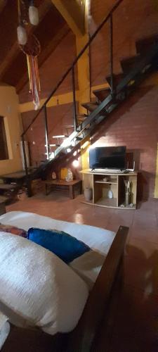 Un dormitorio con una cama grande y un altillo. en Cabañas Akasha, en San Rafael