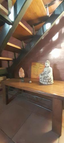 una estatua sentada en la parte superior de un banco de madera en Cabañas Akasha, en San Rafael
