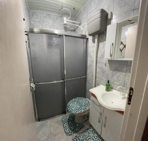 een badkamer met een douche, een toilet en een wastafel bij Casa Ágata in Cidreira