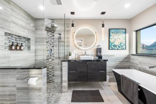 uma casa de banho com uma banheira, um lavatório e um espelho. em Seven Canyons Sedona Luxury with Panoramic Views em Sedona