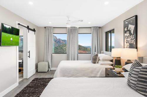 1 dormitorio con 2 camas y TV de pantalla plana en Seven Canyons Sedona Luxury with Panoramic Views, en Sedona