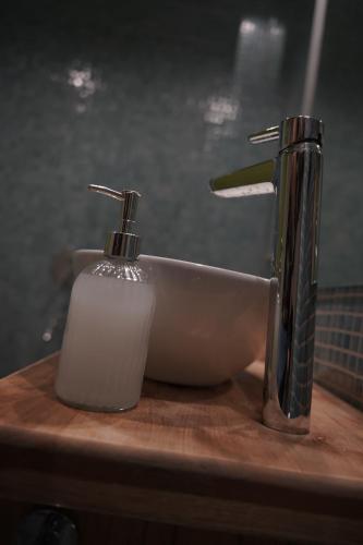 - un lavabo dans la salle de bains avec un distributeur de savon à côté dans l'établissement Studio San Martin, à Mendoza