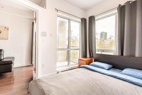 a bedroom with a large bed and two windows at One bedroom apartment - 507 in Montreal