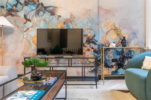 - un salon avec une télévision murale dans l'établissement Trendy 3-Bedroom Hackney Pad, à Londres