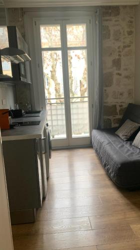 une cuisine avec une grande fenêtre et un canapé dans l'établissement Studio meublé, à Nice