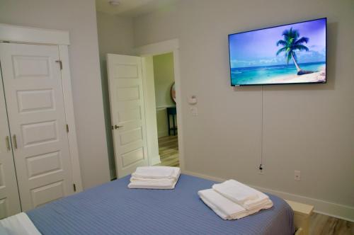 Habitación con cama y TV en la pared. en Peaceful Shores Retreat, en Panama City Beach