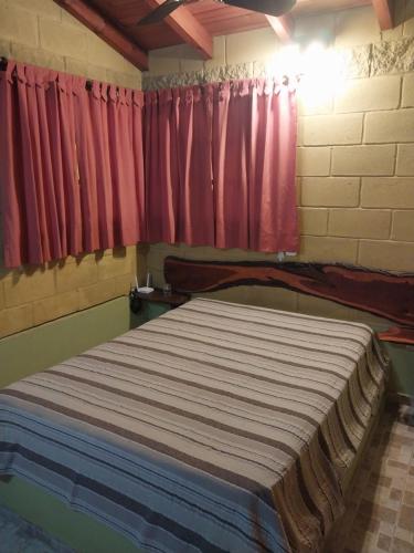Cette chambre comprend un grand lit et des rideaux rouges. dans l'établissement La Soñada, à La Granja