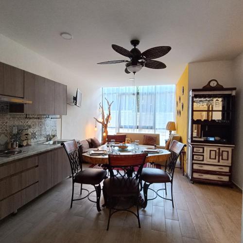 a kitchen with a table and chairs and a ceiling fan at RIBERA DE CHAPALA Suites in Chantepec