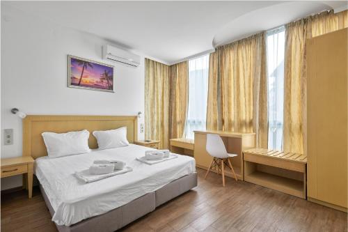 a hotel room with a bed and a window at Paradise Apartments Primorsko in Primorsko