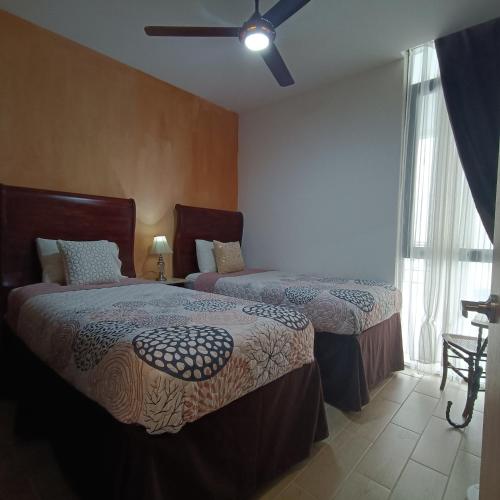 a bedroom with two beds and a window at RIBERA DE CHAPALA Suites in Chantepec