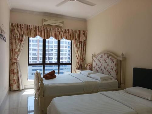 a bedroom with two beds and a large window at Town Condo - Marina Court Kota Kinabalu in Kota Kinabalu