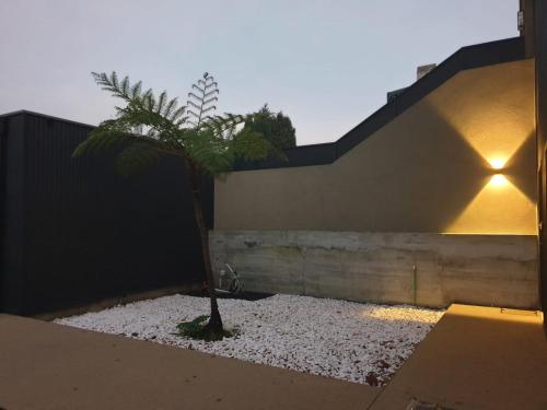 a palm tree in a gravel yard next to a building at Poetikblue by We Do Living in Porto