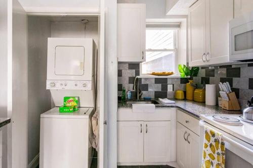 a kitchen with white cabinets and a washer at Viola’s Place in Washington