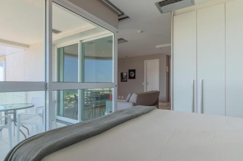 a bedroom with a large bed and a table at Flat Ocean View in Rio de Janeiro