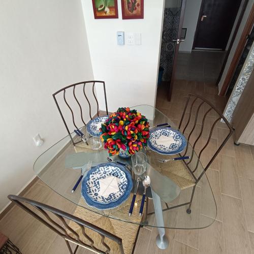 a glass table with two chairs and a vase of flowers at RIBERA DE CHAPALA Suites in Chantepec