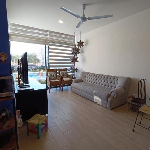 a living room with a couch and a tv in it at RIBERA DE CHAPALA Suites in Chantepec