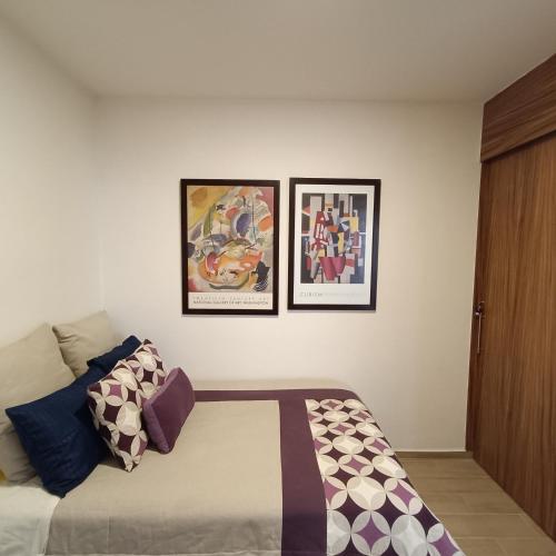 a bedroom with three pictures on the wall at RIBERA DE CHAPALA Suites in Chantepec