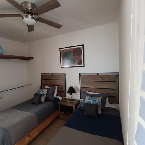 a bedroom with two beds and a ceiling fan at RIBERA DE CHAPALA Suites in Chantepec