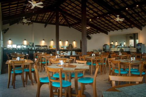een eetkamer met houten tafels en stoelen bij Pousada Aroma do Mar by Latitud Hoteles in Búzios