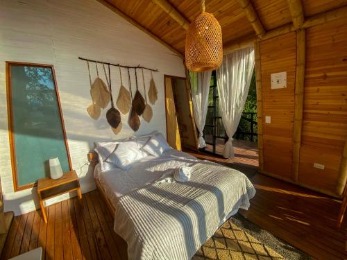 a bedroom with a bed in a wooden room at NaturalMente Glamping in San Antonio del Tequendama
