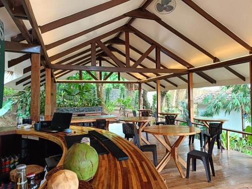 a restaurant with wooden tables and chairs and a river at Kawai Duli Bungalows 1 in Duli