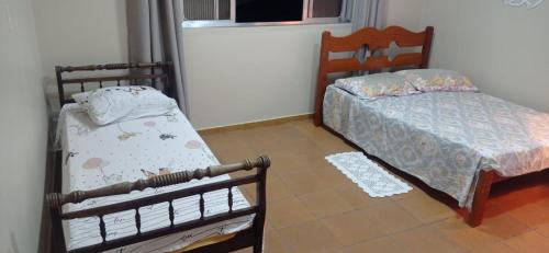 - une chambre avec 2 lits jumeaux et une fenêtre dans l'établissement Suíte Félix Praia do Anil Angra dos Reis, à Angra dos Reis