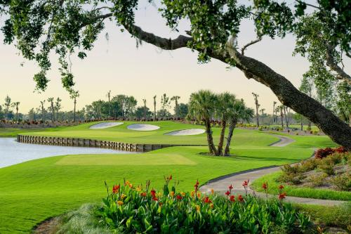 a golf course with a green and a pond at Sunseeker Resort Florida Gulf Coast, Curio Collection Hilton in Port Charlotte