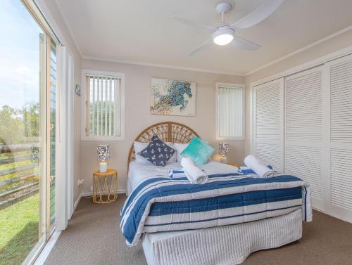 a bedroom with a bed with blue and white pillows at Hastings Cove Holiday Apartments in Hastings Point