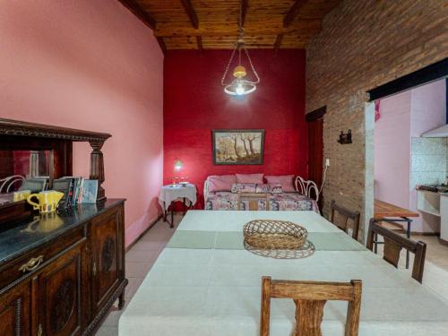 comedor con mesa y pared roja en Refugio Bohemio-con patio y asador, en Villa María