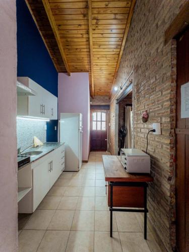 a kitchen with a table and a white refrigerator at Refugio Bohemio-con patio y asador in Villa María