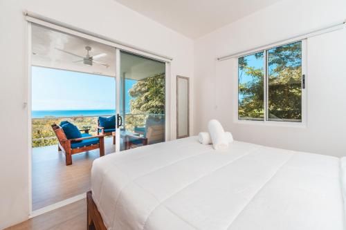 a bedroom with a bed and a view of the ocean at Buena Vista Ocean View Apartments Santa Teresa in Santa Teresa Beach
