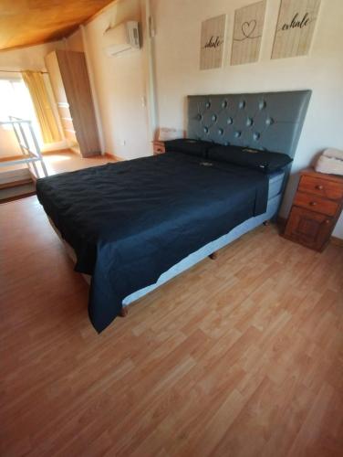 a large bed in a room with a wooden floor at Atardeceres del Valle in La Bolsa
