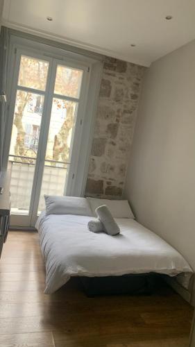 une chambre avec un grand lit avec deux fenêtres dans l'établissement Studio meublé, à Nice